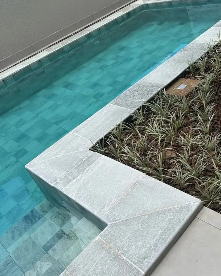 Detalhe de borda de piscina em pedra natural clara